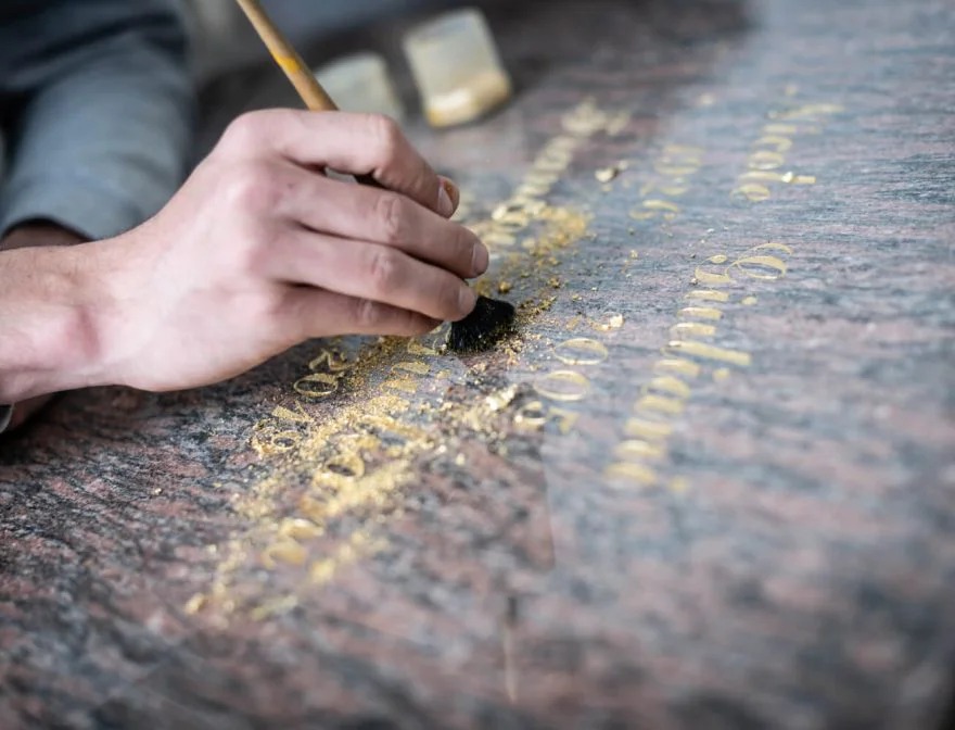 Travail de gravure funéraire dorée